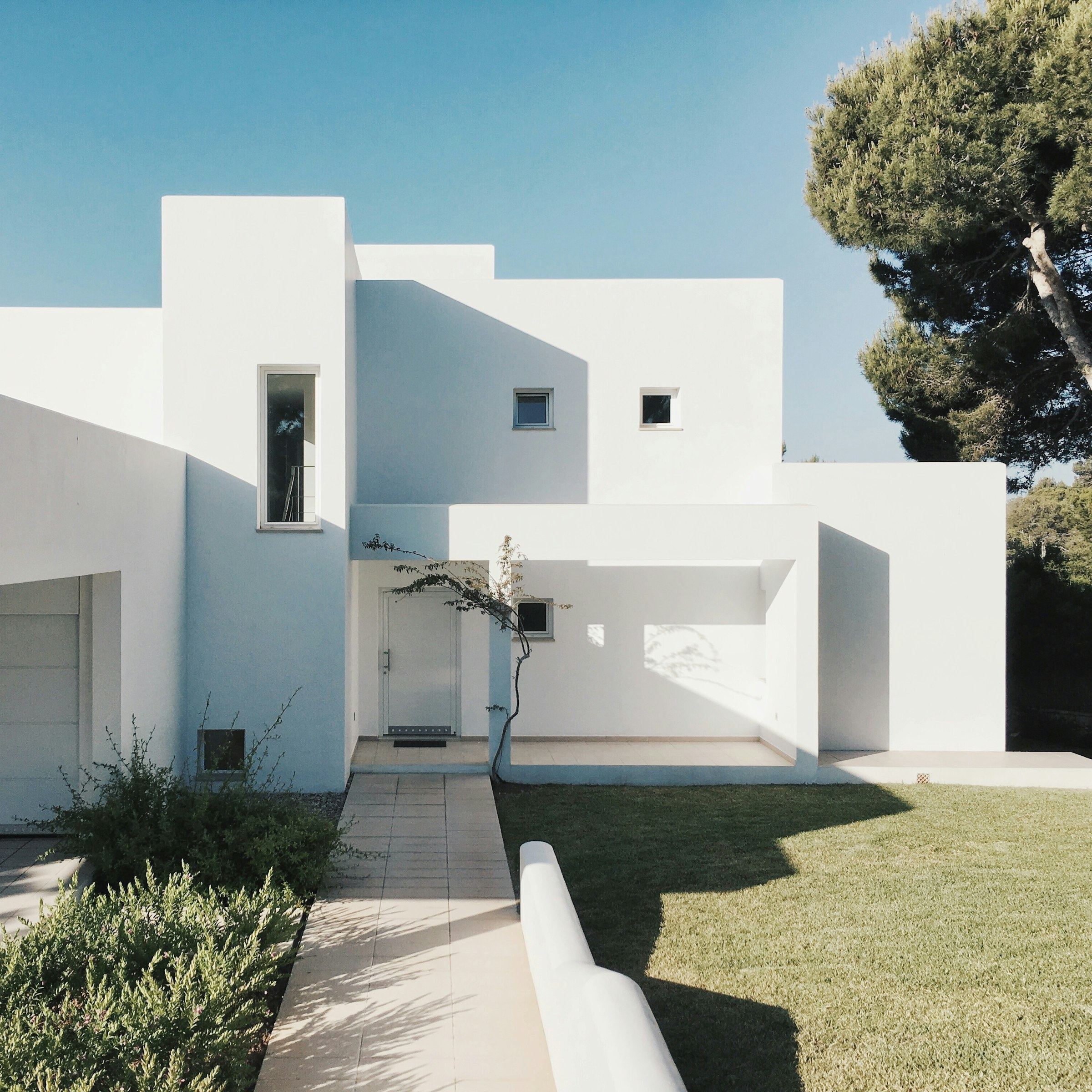 Fachada blanca con sombras duras al mediodía