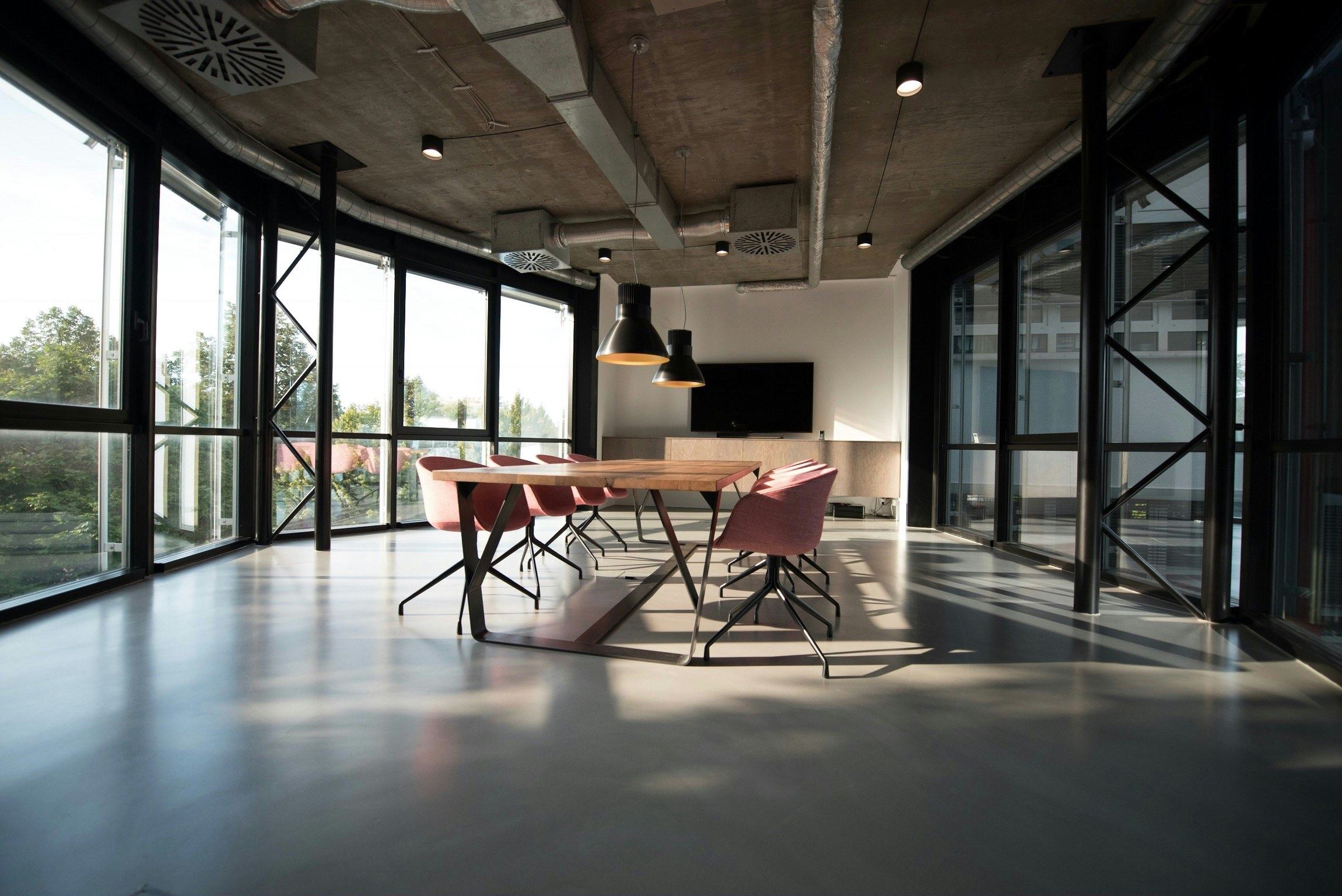Planta de oficinas con ventanales y mesas largas